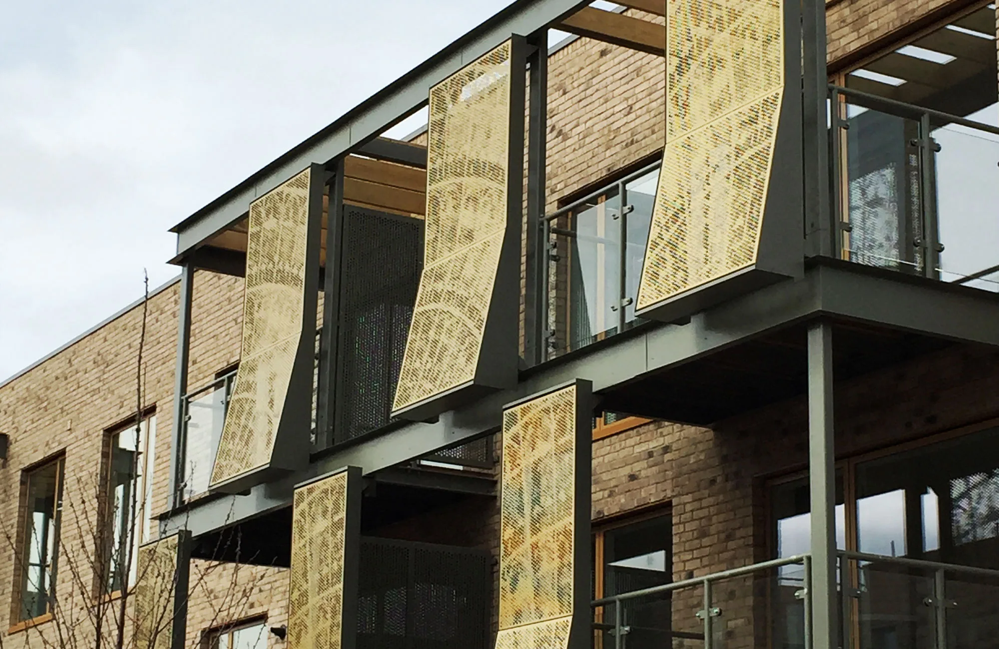 Bespoke perforated gold cladding panels by Everform — Countryside Homes